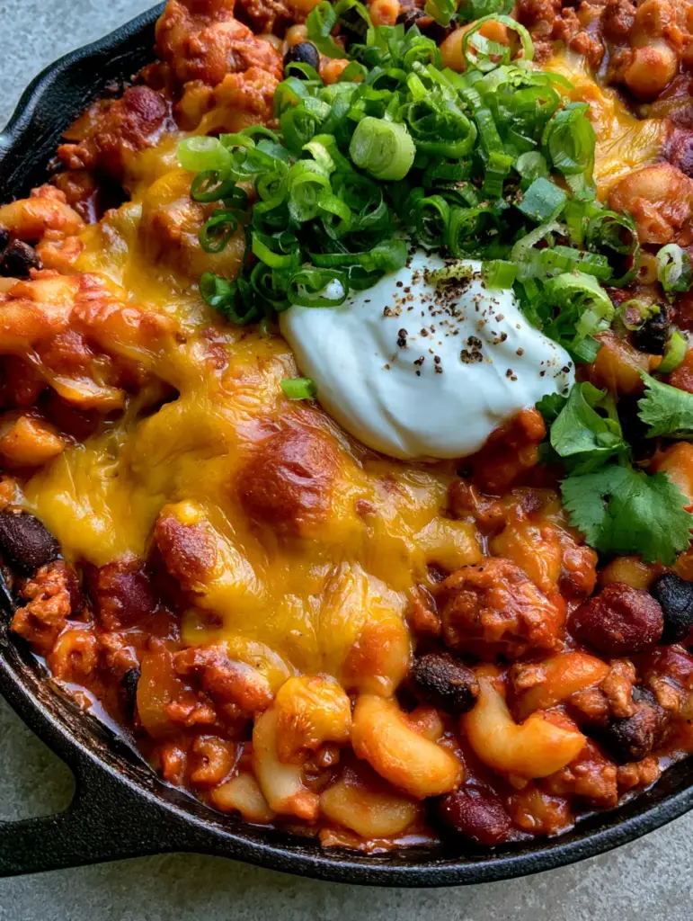Extreme close-up of glossy tomato chili sauce coating al dente elbow macaroni and black beans in Vegetarian Chili Mac.